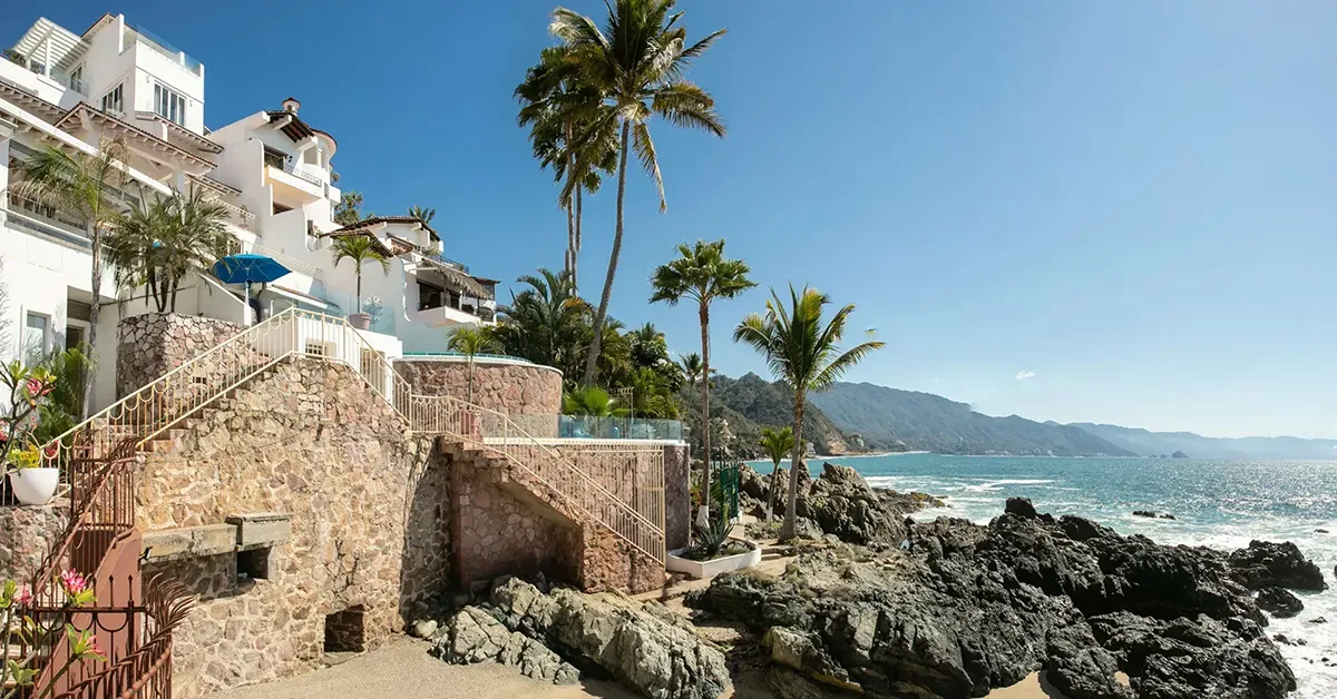 Casa Karma white villa exterior above a rocky shoreline — Puerto Vallarta, Mexico