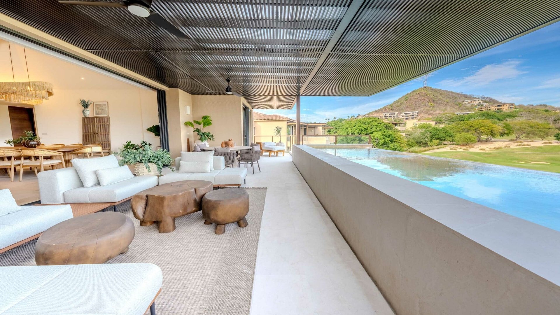 Condo 7 Eight 406 covered terrace seating beside a pool with golf and mountains beyond — Punta Mita Nayarit, Mexico