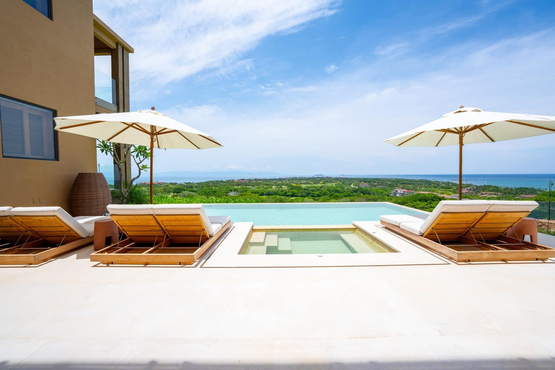 Villa del Sol at Vistas 1 pool terrace with four loungers, umbrellas and a sea view — Punta Mita Nayarit, Mexico